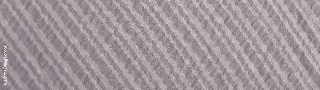 Foto: Nahmaufnahme der gecrinkelten Oberfläche von Spannbettlaken aus Seersucker.