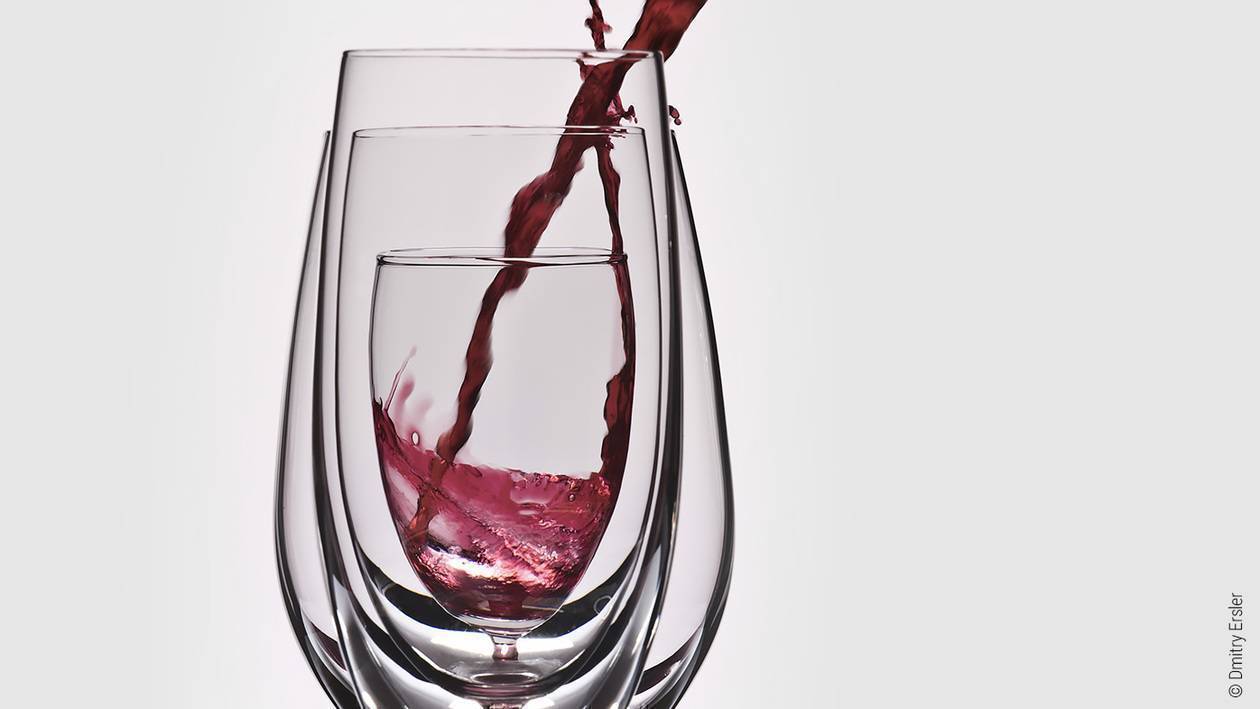 Foto: Drei unterschiedlich große Weingläser ineinander. Von rechts oben wird Wein in das kleinste Glas in der Mitte gegossen.