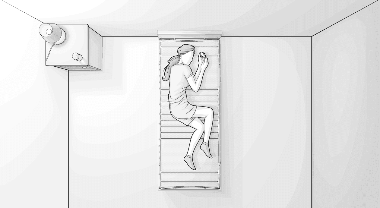 Illustration eines Schlafzimmers aus Vogelperspektive: Im schmalen Bett liegt eine Person in Embryohaltung auf einem Topper 80x200 cm.