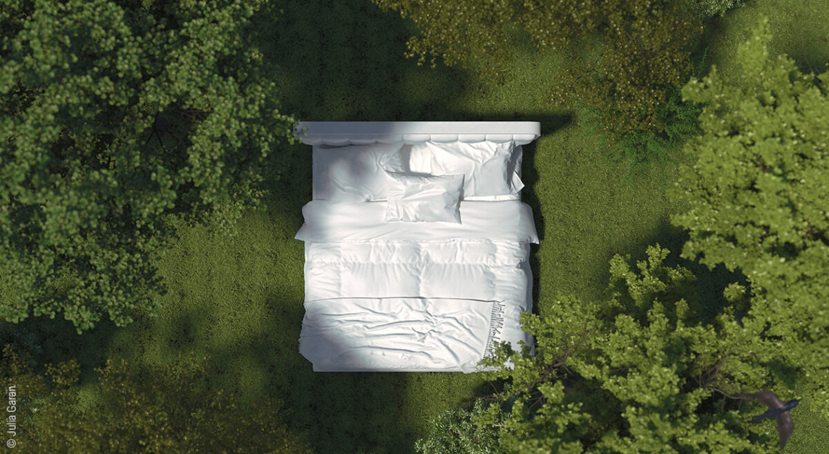 Titelbild zur Naturmatratze: Ein weiß bezogenes Bett auf einer grünen Waldlichtung aus Vogelperspektive.
