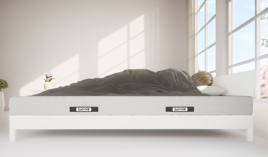 Foto: Eine Person liegt in der Seitenlage auf einer BODYGUARD® Matratze.