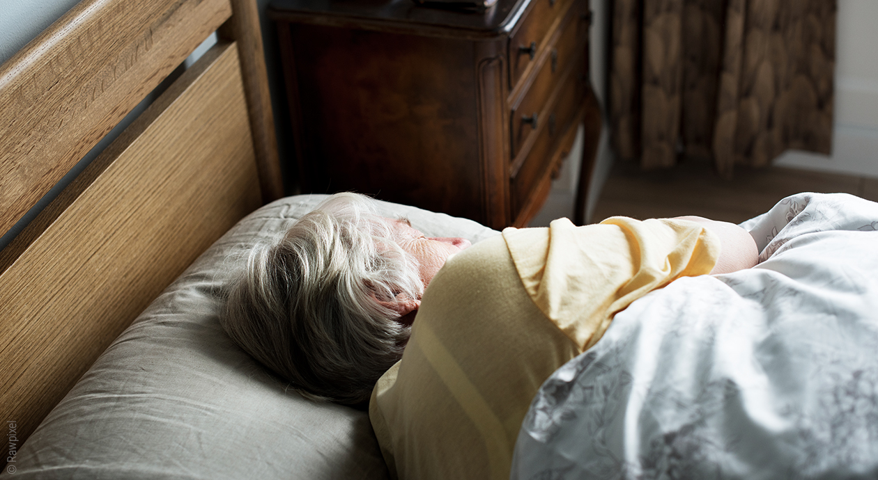 Beitragsbild Demenz vorbeugen: Eine ältere Person liegt schlafend im Bett.