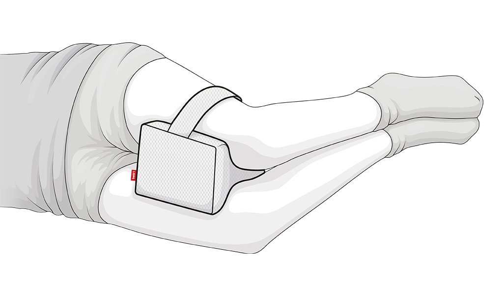 Illustration: Unterkörper einer Person in Seitenlage. Ihre Beine sind leicht angewinkelt. Zwischen den Oberschenkeln klemmt ein Kniekissen mit rotem bett1-Etikett. Das Kissen ist am oberen Bein mit einer Halteschlaufe befestigt.
