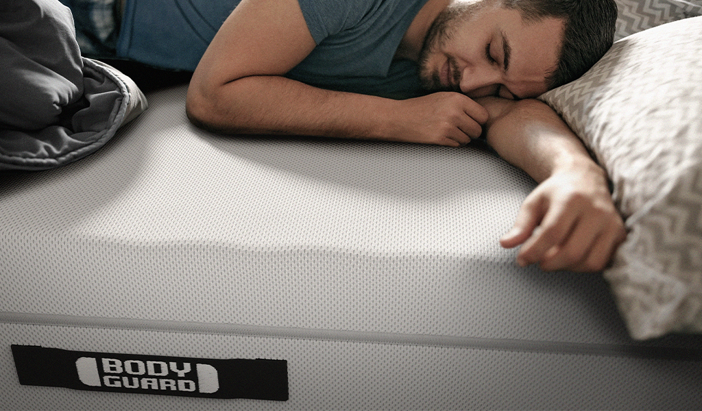 Foto: Eine Person liegt schlafend auf einer BODYGUARD® Matratze.