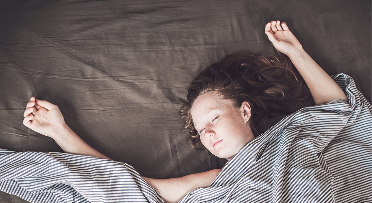 Titelbild ohne Kissen schlafen: eine Person liegt mit geschlossenen Augen ohne Kissen in Rückenlage im Bett.