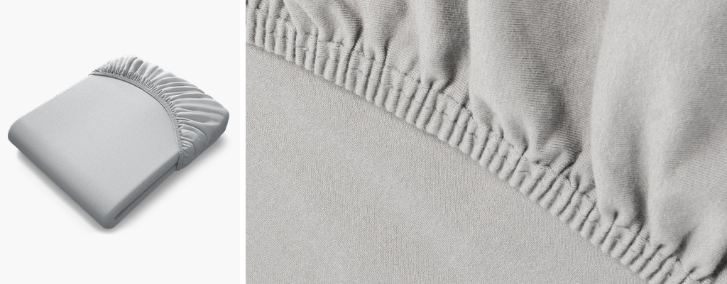Foto links: Das BODYGUARD Jersey-Spannbettlaken in Silber. 
Foto rechts: Nahaufnahme des Gummizugs eines grauen Jersey-Spannbettlakens.