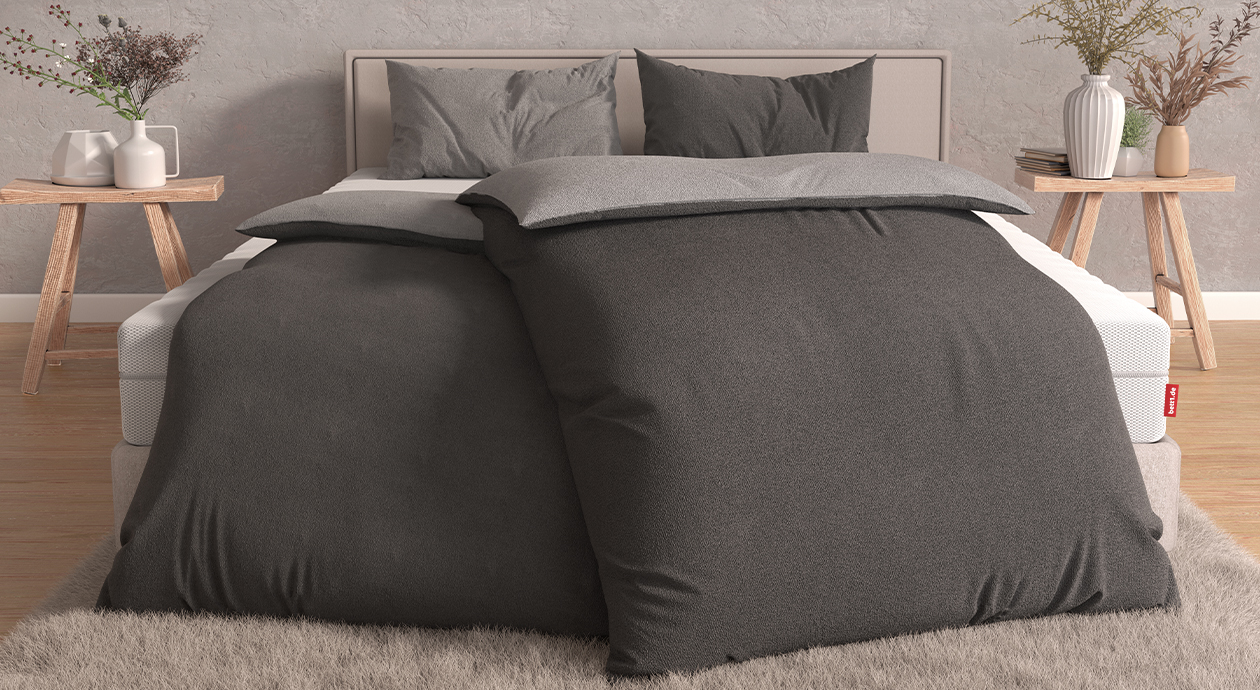 Doppelbett mit dunkelgrauer Satin-Bettwäsche und bett1.de BODYGUARD Matratze.