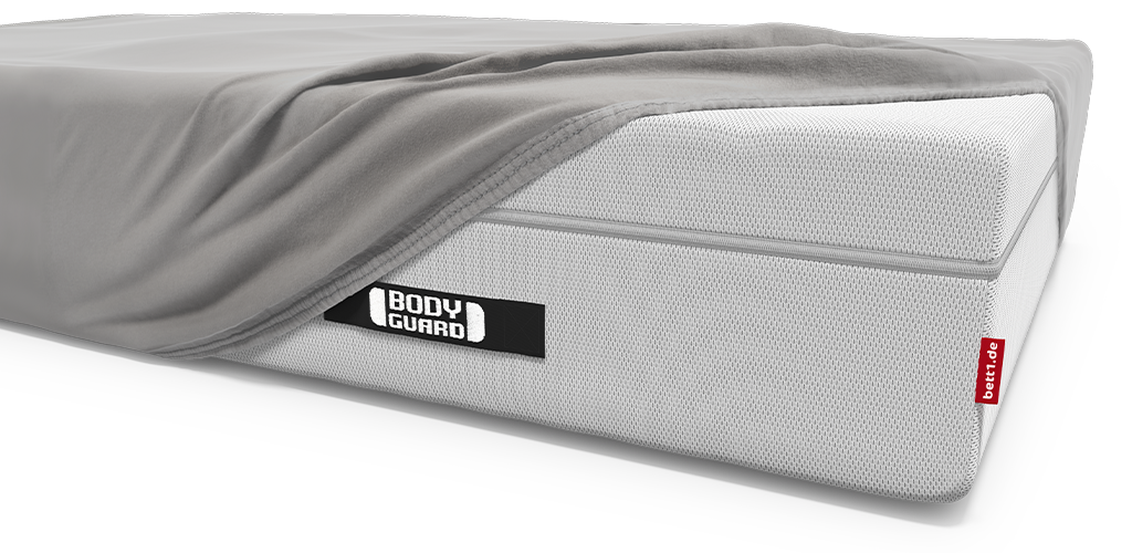 Die BODYGUARD Boxspring Matratze bezogen mit dem BODYGUARD Spannbettlaken extra hoch. An einer Ecke ist das Spannbettlaken abgezogen, sodass die blanke Matratze zu sehen ist.
